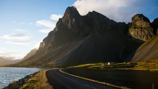 An empty road section on the Island round trip in 10 days directly by the sea with impressive mountains on the street side
