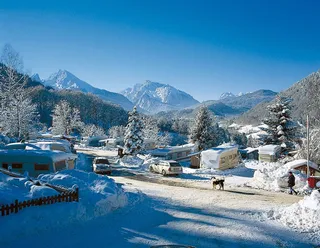 The campsite Allweglehen in winter. You can see the mountains and some vehicles standing in the square.