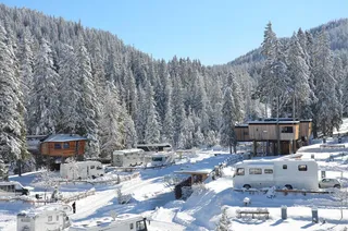 The snowy Caravan Park Sexten with a few campers and huts.