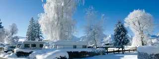 The snowy campsite Hopfensee. Some campers and campers are on the square.